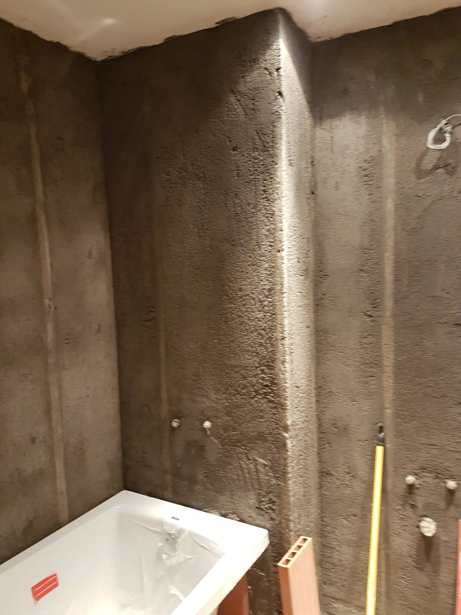 Bañera colocada frente a paredes regularizadas antes de instalar el revestimiento